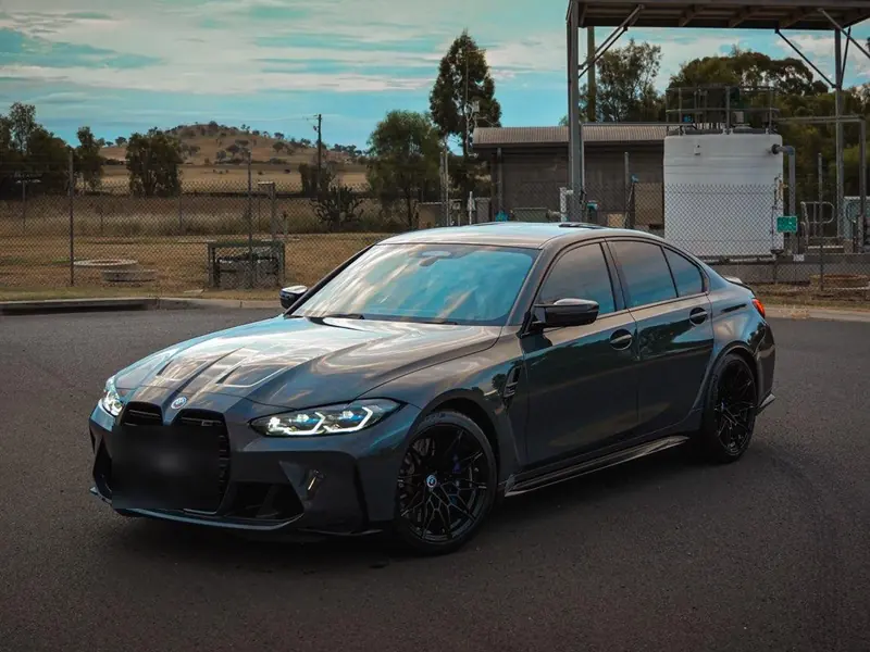 Grey BMW M3 Competition detailed and parked on open bitumen