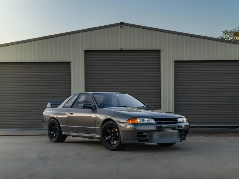 Gunmetal Nissan Skyline R32 GT-R outside the garage