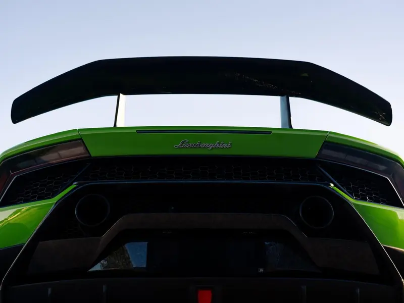 Rear wing and quad exhausts on a coated green Lamborghini Huracan