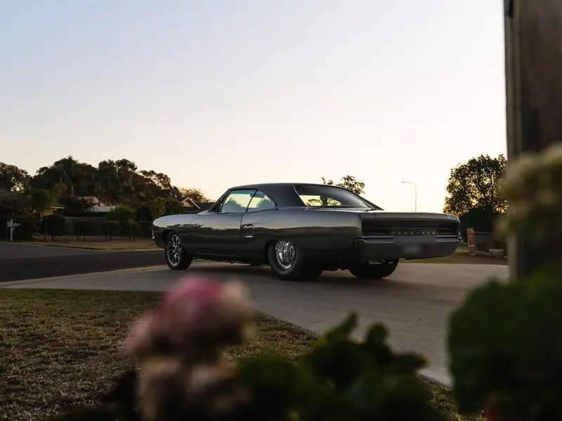Grey classic Plymouth muscle car detailed to a deep shine at dusk